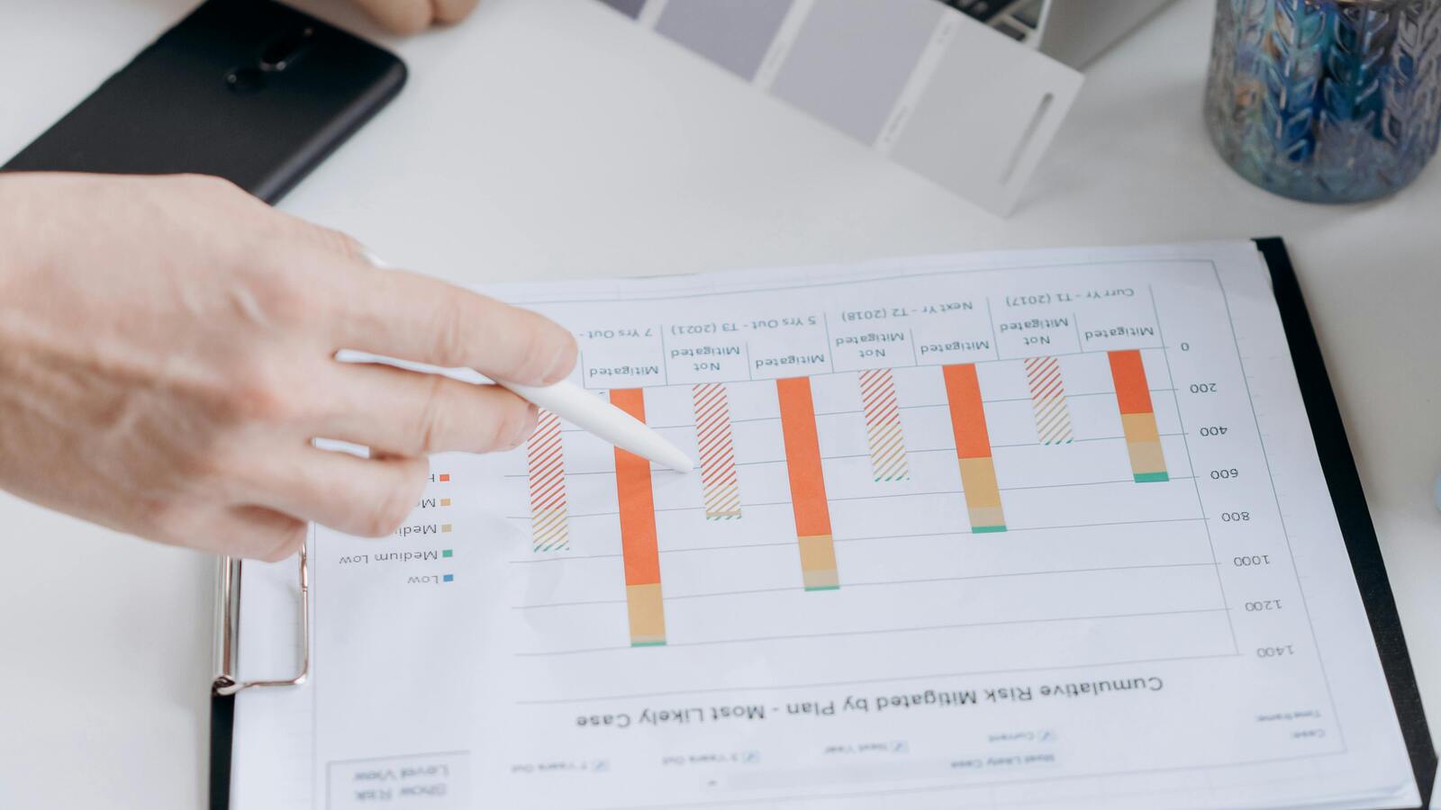 Printed compliance chart beside a laptop, representing Microsoft-native AI governance controls